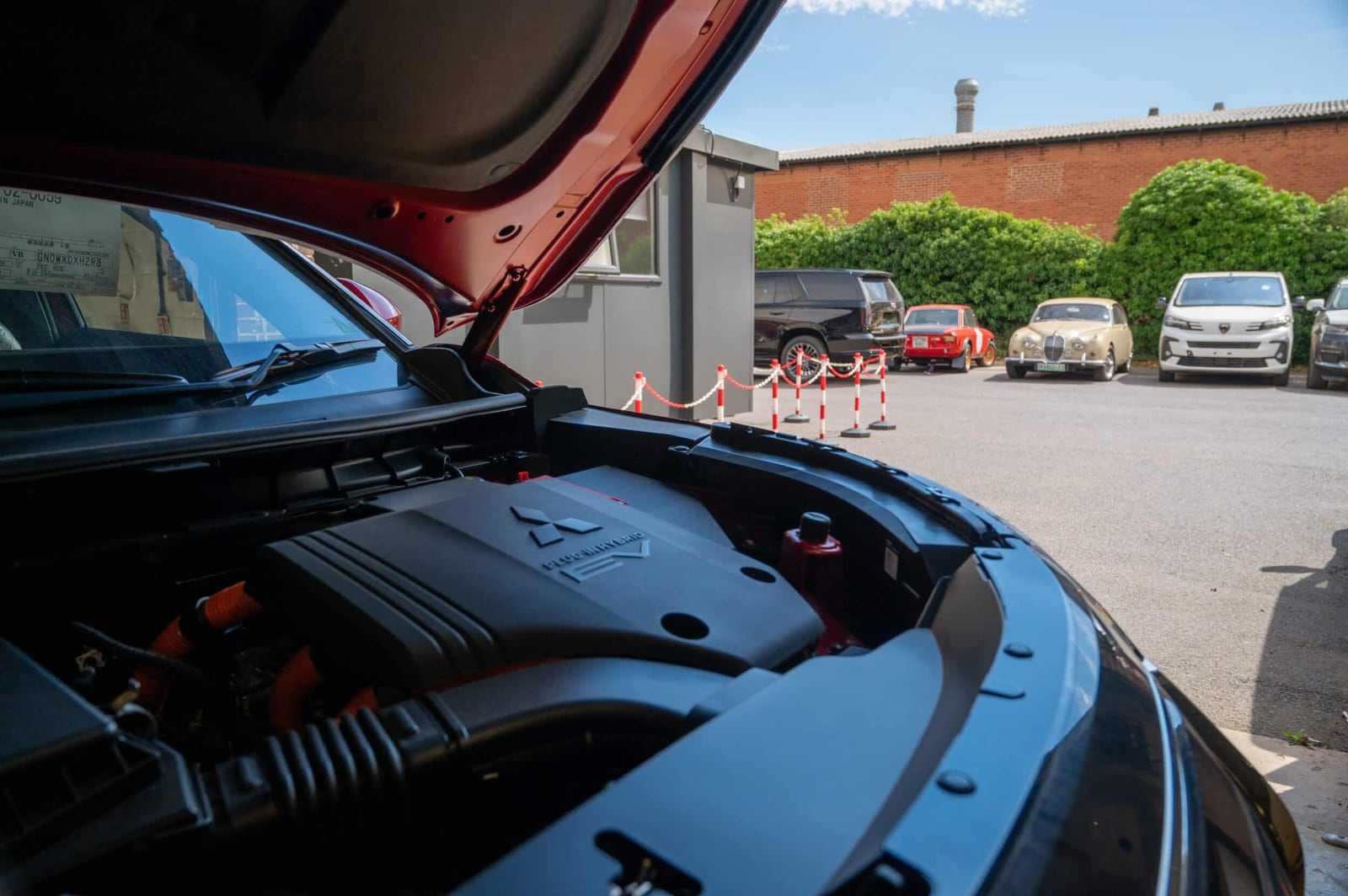 A red SUV outside our workshop with the bonnet raised for inspection